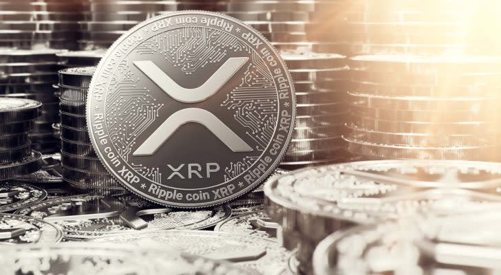 A concept token for XRP with stacks of tokens in the background. XRP price predictions.