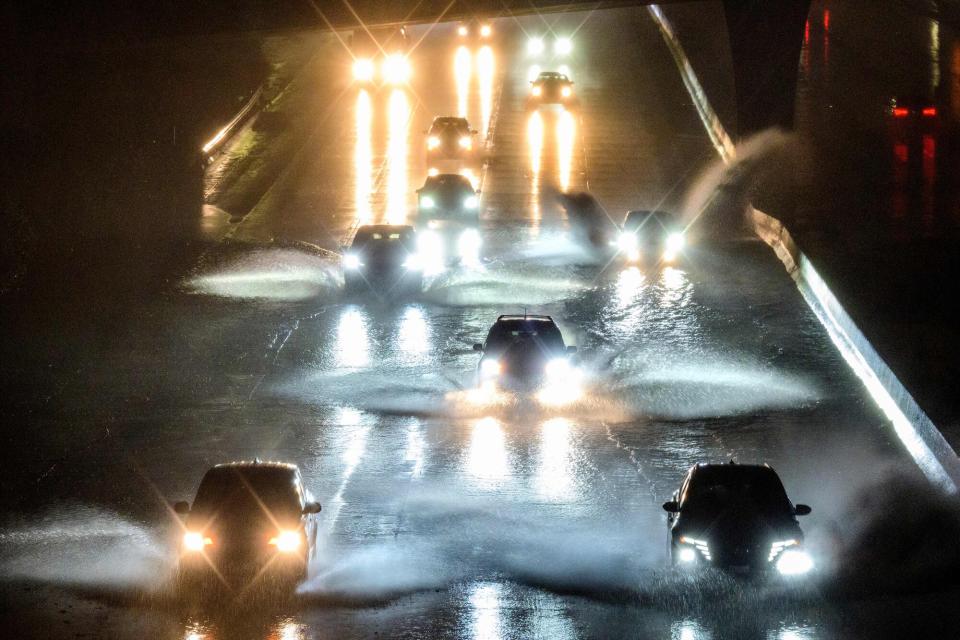 Drivers barrel into standing water on Interstate 101 in San Francisco, California on January 4, 2023. - A bomb cyclone smashed into California on January 4, 2023, bringing powerful winds and torrential rain that was expected to cause flooding in areas already saturated by consecutive storms.
