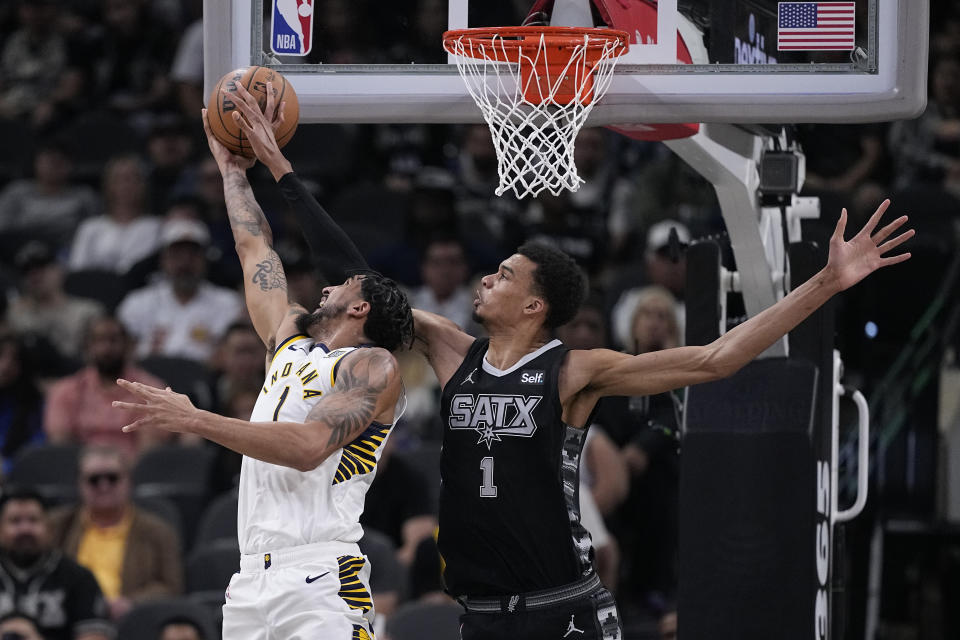 Indiana Pacers forward Obi Toppin, left, is blocked by San Antonio Spurs center Victor Wembanyama (1) as he tries to score during the first half of an NBA basketball game in San Antonio, Sunday, March 3, 2024. (AP Photo/Eric Gay)