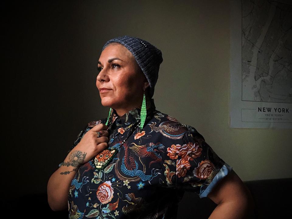 Ori Aguila poses for a portrait in their home studio in Brooklyn, New York, on Dec. 16, 2021. Aguila, 47, was adopted from foster care and is now a trauma specialist.