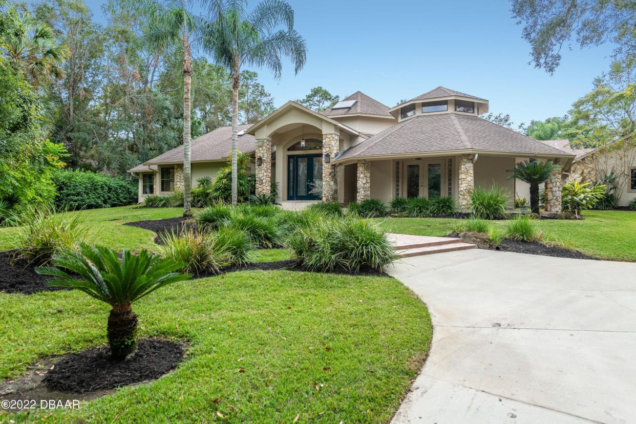 A long winding driveway slowly unveils the beauty of this two-acre property in Ormond Beach's Heritage Forest community.