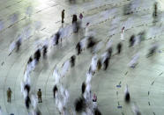In this photo taken with a slow shutter speed, security members ensure social distancing to help curb the spread of the coronavirus, as Muslim pilgrims circumambulate the Kaaba, during the minor pilgrimage, known as Umrah, marking the holy month of Ramadan, in the Muslim holy city of Mecca, Saudi Arabia, Tuesday, April 13, 2021. During Ramadan, the holiest month in Islamic calendar, Muslims refrain from eating, drinking, smoking and sex from dawn to dusk. (AP Photo/Amr Nabil)