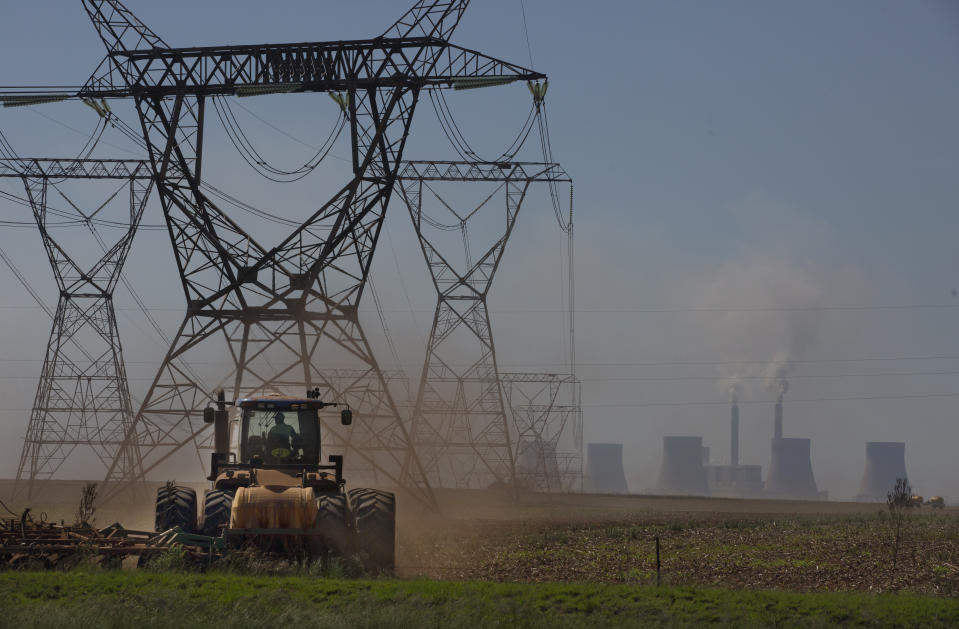 The land is ploughed under electrical pylons leading from a coal-powered electricity generating plant east of Johannesburg, Thursday, Nov. 17 2022. Living in the shadow of one of South Africa’s largest coal-fired power stations, residents of Masakhane fear job losses if the facility is closed as the country moves to cleaner energy. A significant polluter because it relies on coal to generate about 80% of its electricity, South Africa plans to reduce that to 59% by 2030 by phasing out some of its 15 coal-fired power stations and increasing its use of renewable energy. (AP Photo/Denis Farrell)