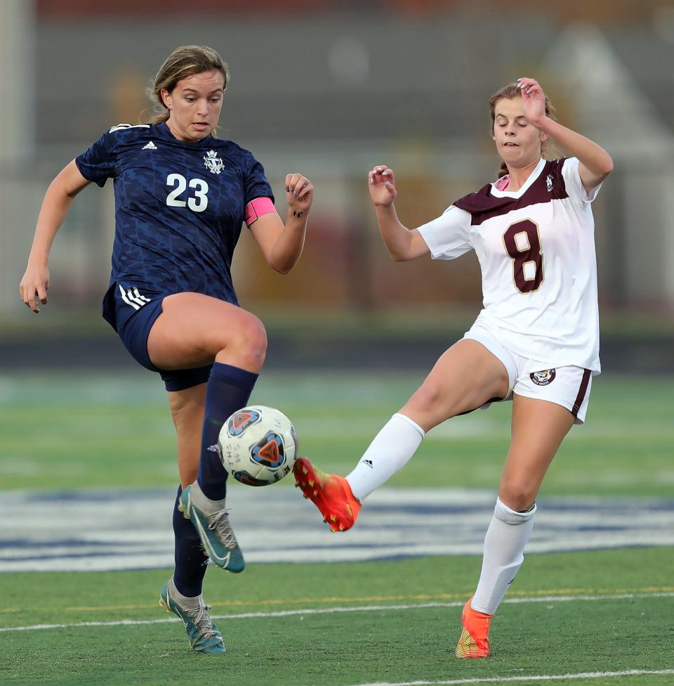 Twinsburg's Brenna Utrup, left, kicks the ball against Stow's Corinne Casenhiser during the first half of a Division I district semifinal soccer game, Monday, Oct. 24, 2022, in Twinsburg, Ohio.