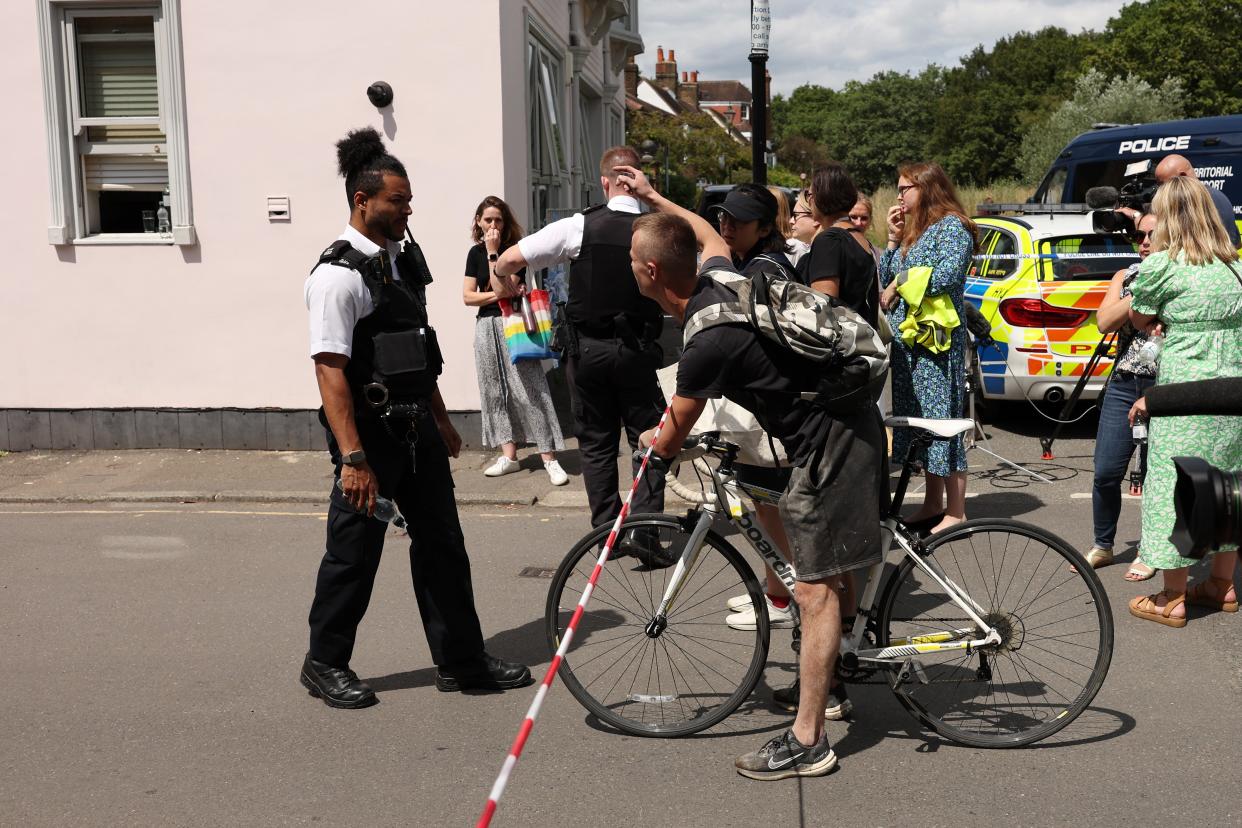 People gather outside a cordon at the scene of a car crash at a school on 6 July 2023 in Wimbledon, England (Getty Images)