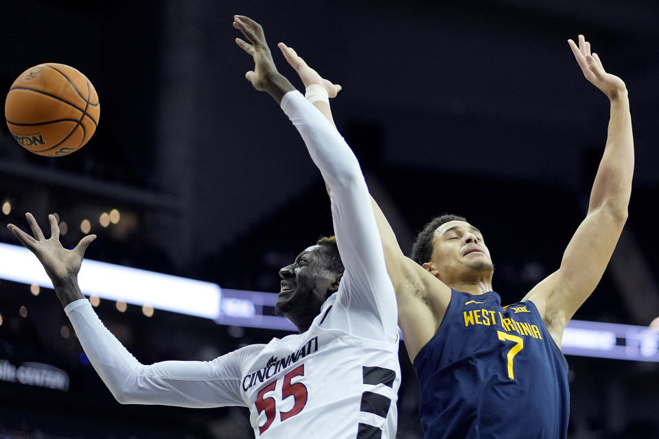 Cincinnati forward Aziz Bandaogo (55) beats West Virginia center Jesse Edwards (7) to a rebound during the first half of an NCAA college basketball game Tuesday, March 12, 2024, in Kansas City, Mo. (AP Photo/Charlie Riedel)
