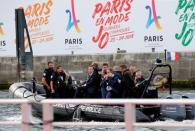 French President Emmanuel Macron (C) departs in a security boat on the Seine River in Paris, France, June 24, 2017. REUTERS/Jean-Paul Pelissier