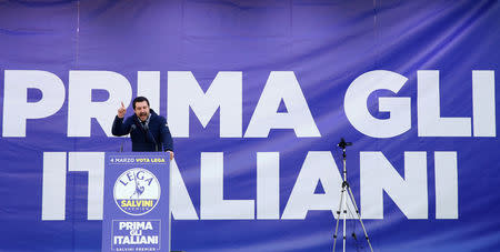 Italian Northern League leader Matteo Salvini speaks during a political rally with a banner reading "Italian first" in the back, in Milan, Italy February 24, 2018. REUTERS/Tony Gentile