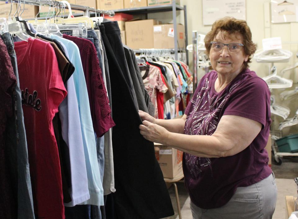 Monroe resident Brenda Thomas works in receiving at the Thrift Shop Association of Monroe where she sorts donated items and hangs clothing before it's tagged.
