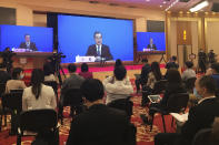 China's Foreign Minister Wang Yi is seen broadcasted remotely on big screens at the media center during a press conference held on the sideline of the National People's Congress in Beijing on Sunday, May 24, 2020. (AP Photo/Ken Moritsugu)