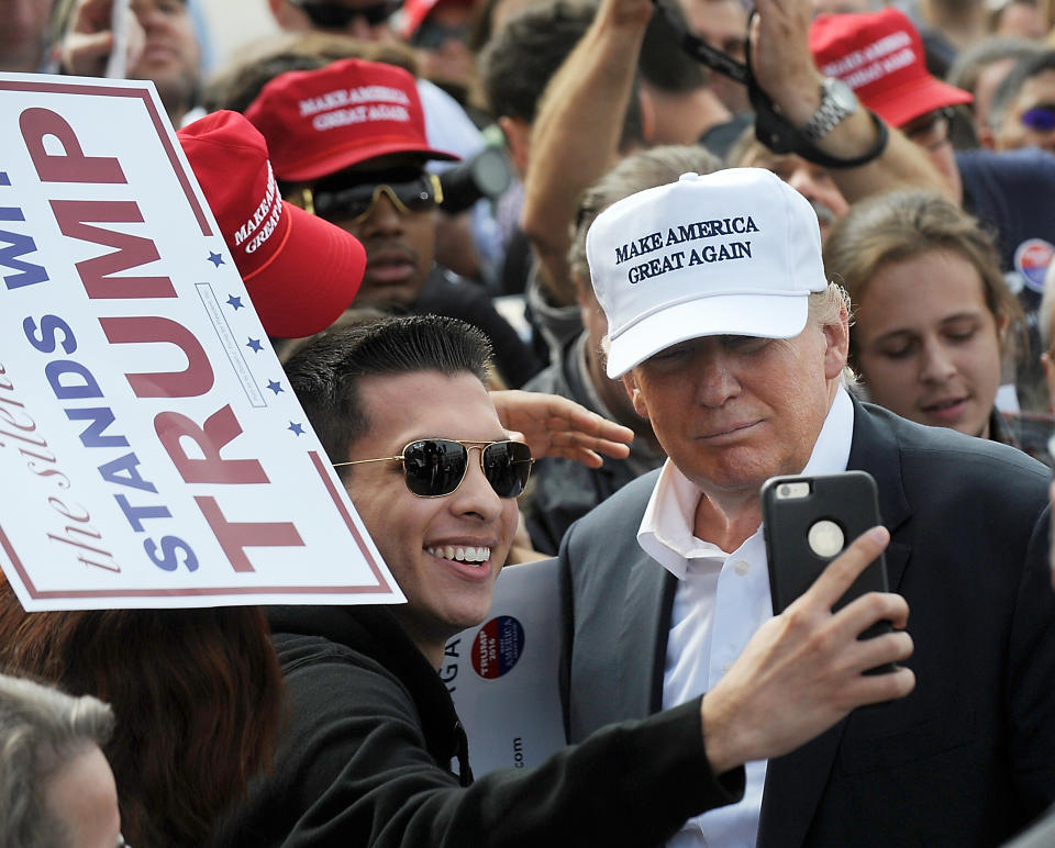 A supporter of Donald Trump takes a selfie with the Republican presidential candidate at a rally in front of the USS Wisconsin on October 31, 2015 in Norfolk, Virginia. . With just 93 days before the Iowa caucuses Republican hopefuls are trying to shore up support amongst the party. (Photo by Sara D. Davis/Getty Images)