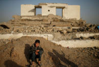 A displaced Iraqi boy sits in front of a destroyed building as he waits to get into Hamam al-Alil camp, south of Mosul, Iraq. REUTERS/Suhaib Salem