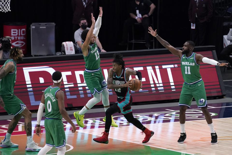 Dallas Mavericks' Willie Cauley-Stein, Josh Richardson (0), Jalen Brunson (13) and Tim Hardaway Jr. (11) defend as Memphis Grizzlies' Ja Morant (12) breaks to the basket for a shot attempt in the second half of an NBA basketball game in Dallas, Monday, Feb. 22, 2021. (AP Photo/Tony Gutierrez)