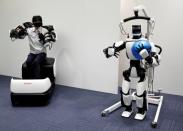 An employee of Toyota Motor Corp. demonstrates T-HR3 humanoid robot which will be used to support the Tokyo 2020 Olympic and Paralympic Games, during a press preview in Tokyo