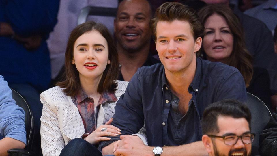 Lily Collins and Thomas Cocquerel sit at LA Lakers Game in 2014