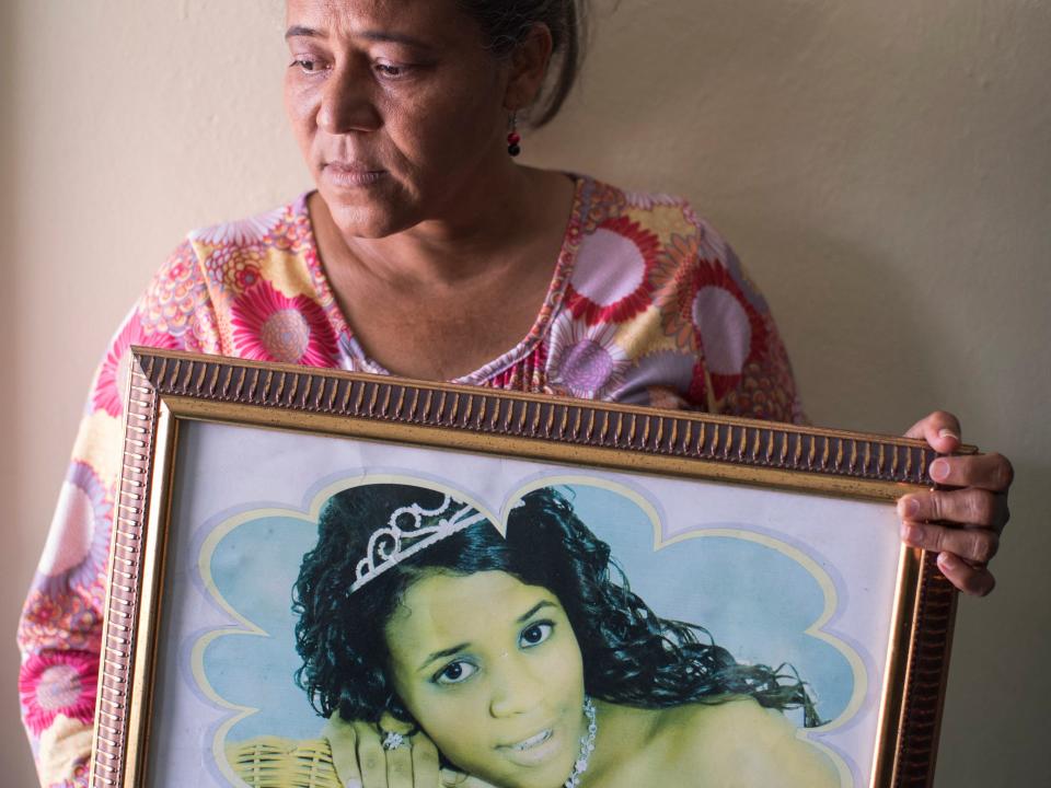 Rosa Hernandez holds a picture of her daughter Rosaura Almonte who died in 2012 for being denied treatment for her leukemia due to being pregnant, at her house in Santo Domingo on March 16, 2021.