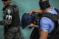 <p>During a military police operation in Hato de Enmedio neighborhood in the capital Tegucigalpa, a young men allegedly belonging to the 18th street criminal gang, or Mara-18, is escorted away. (Photo: Francesca Volpi) </p>