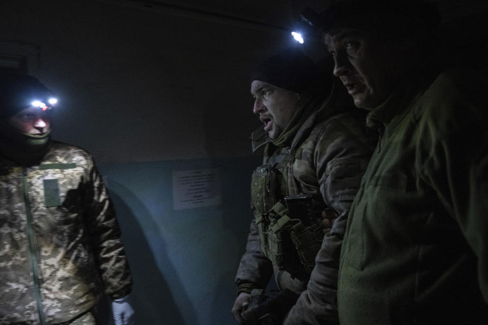 Ukrainian military medics help an injured comrade evacuated from the battlefield into a hospital in Donetsk region, Ukraine, Monday, Jan. 9, 2023. (AP Photo/Evgeniy Maloletka)