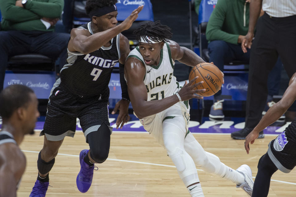 Sacramento Kings guard Terrence Davis (9) defends against Milwaukee Bucks guard Jrue Holiday (21) during the second half of an NBA basketball game in Sacramento, Calif., Saturday, April 3, 2021. The Bucks won 129-128. (AP Photo/Randall Benton)