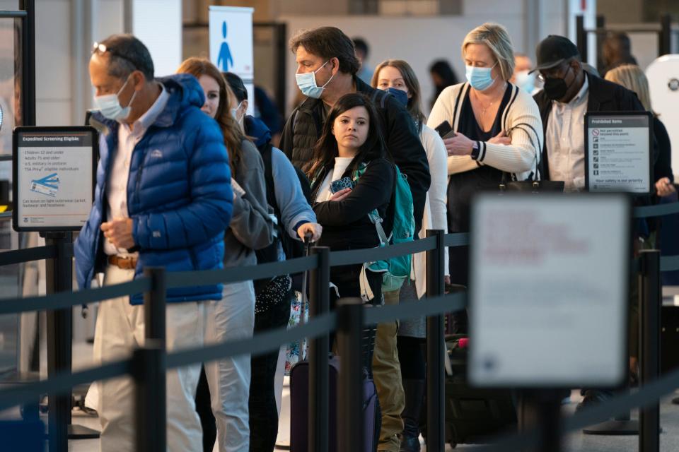 Passengers wait in line at the security checkpoint at Ronald Reagan Washington National Airport, Tuesday, April 19, 2022, in Arlington, Va.