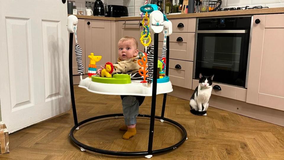 baby boy using walker in kitchen 