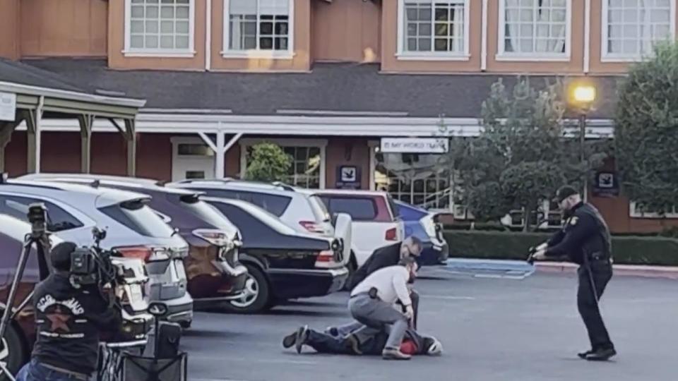 Officers take a man identified as Zhao Chunli into custody after he drove to a sheriff's office media staging area following multiple shootings in Half Moon Bay that left at least seven people dead, January 23, 2023. / Credit: CBS