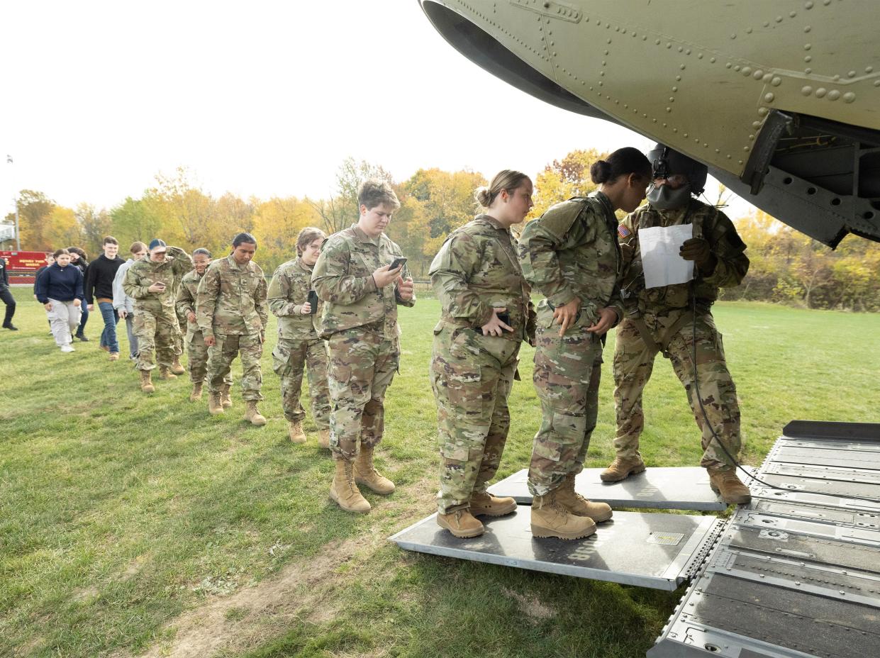 Perry and McKinley Junior ROTC students board a CH-47 Chinook helicopter for a flight at Perry High School on Thursday.