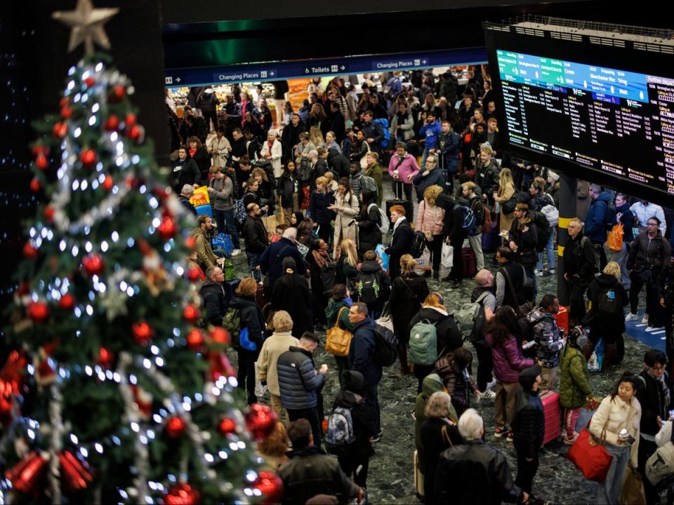Passengers wait for train services to travel from London Euston on Friday as they make their Christmas getaway (EPA)