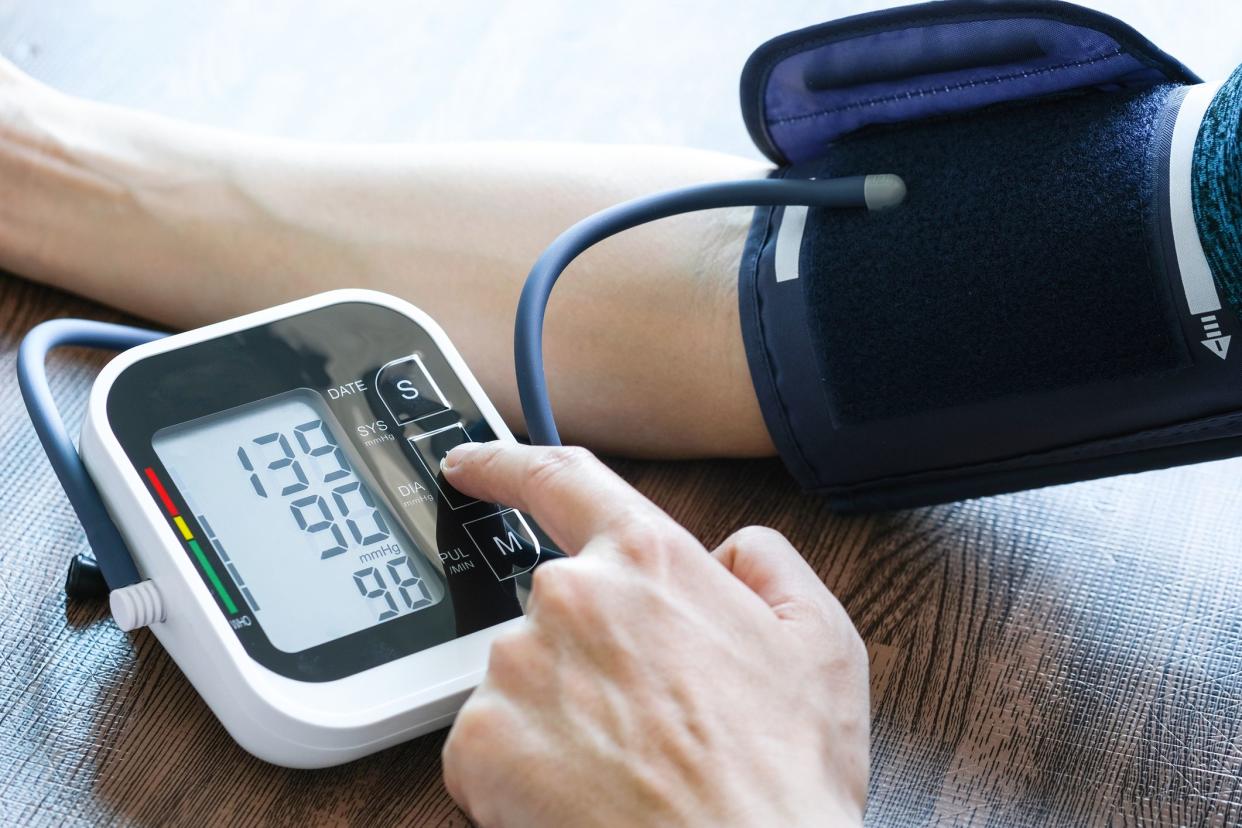 Man checks blood pressure monitor and heart rate monitor with digital pressure gauge. Health care and Medical concept.