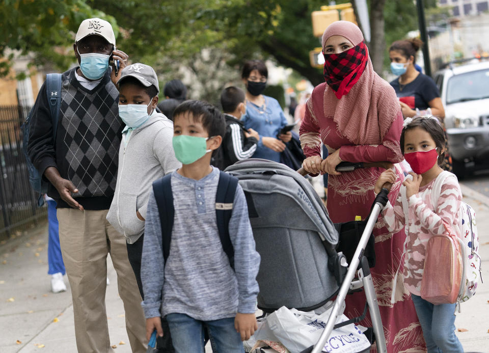 FILE - Parents accompany their children outside PS 179 elementary school in the Kensington neighborhood in the Brooklyn borough of New York, in this Tuesday, Sept. 29, 2020, file photo. Pfizer asked the U.S. government Thursday, Oct. 7, 2021, to allow use of its COVID-19 vaccine in children ages 5 to 11 -- and if regulators agree, shots could begin within a matter of weeks. (AP Photo/Mark Lennihan, File)