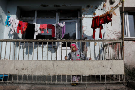 An Afghan migrant child stands in their balcony in Kars, eastern Turkey, April 11, 2018. Picture taken April 11, 2018. REUTERS/Umit Bektas