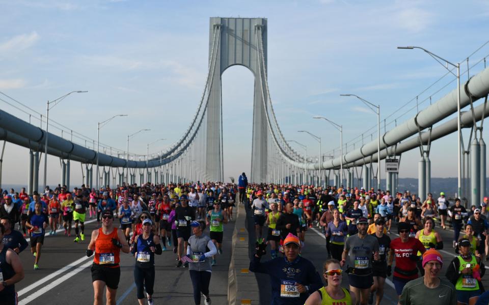 Runners cross the Verrazzano-Narrows Bridge during the 2021 TCS New York City Marathon in New York on November 7, 2021. - After a forced break in 2020, the New York City Marathon is back on for its 50th edition, and with it the countless opportunities to run it for charity, an industry that has become a staple, and hopes to take off again after the pandemic.