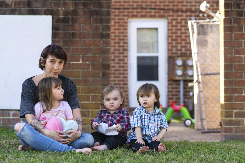 Kandise Norris, shown here with her three children in a Nov. 7 photo outside their home in Somerset County, Maryland, says she has been rebuilding her life since getting treatment for drug addiction in April 2019. The Housing Authority of Crisfield, Maryland, which owns her house, has filed three eviction cases against the 30-year-old since September. (Nick McMillan/Howard Center for Investigative Journalism via AP)