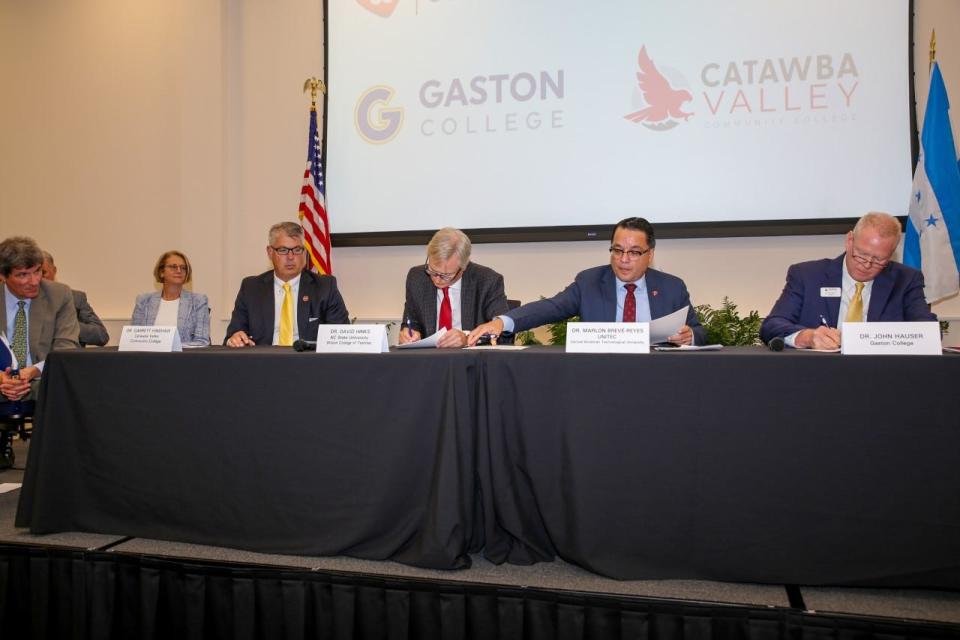 Gaston College President John Hauser, far right, along with other education leaders signed an agreement Monday, Aug. 22, at Gaston College concerning training textile workers in Honduras.