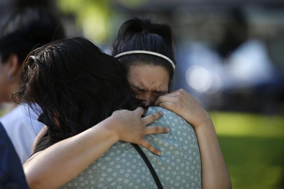 A woman weeps as she is embraced at a memorial site for the victims in Uvalde.