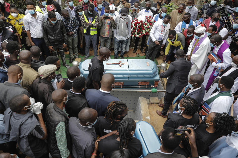 Mourners prepare to bury coronavirus victim 27 year old Nancy Ndanu Musyoka, with her daughter Jaylla Musyoka, in Kakungu village, Kitui county, Kenya, Wednesday, July 28, 2021. Nancy, a high school teacher started feeling unwell and was taken to Kitui referral hospital with breathing complications. (AP Photo/Brian Inganga)