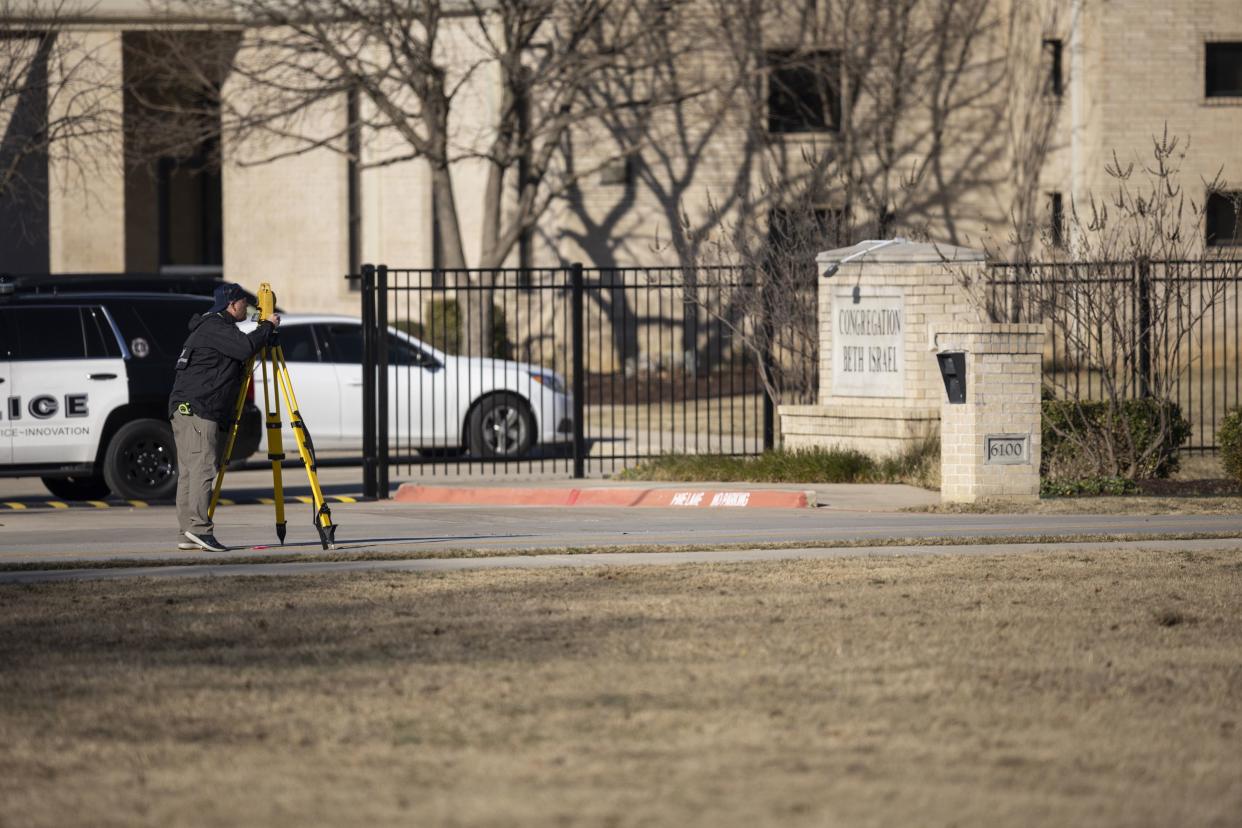 Law enforcement process the scene in front of the Congregation Beth Israel synagogue on Sunday, Jan. 16, 2022, in Colleyville, Texas.