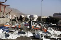 A man walks on the wreckage of a gas station targeted by a Saudi-led air strike in Yemen's capital Sanaa January 4, 2016. REUTERS/Khaled Abdullah