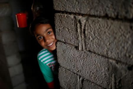 Nine-year-old Iraqi girl Meriam looks out as she stands inside a house, east of Mosul, Iraq July 28, 2017. Picture taken July 28, 2017. REUTERS/Suhaib Salem