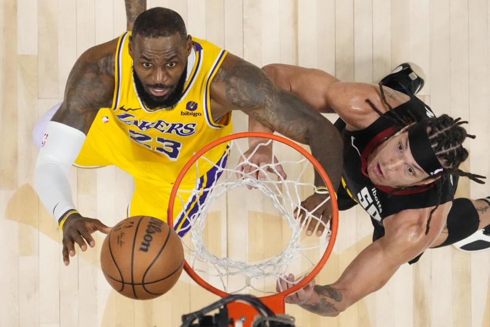 Lakers forward LeBron James, left, and Nuggets forward Aaron Gordon watch as the ball bounces off the rim.