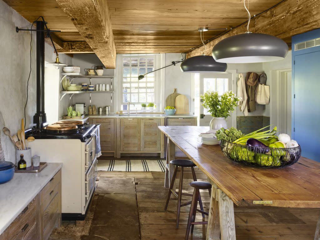 sleek and modern gray colored light fixtures decorate a very rustic kitchen