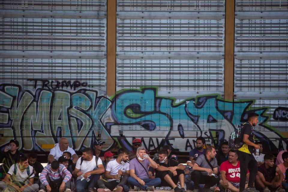 Venezuelan migrants were sat down in rows by U.S. Customs and Border Protection as hundreds were being held in an area underneath the Loop 375 overpass on the embankment of the Rio Grande on Tuesday, Sept. 13, 2022.