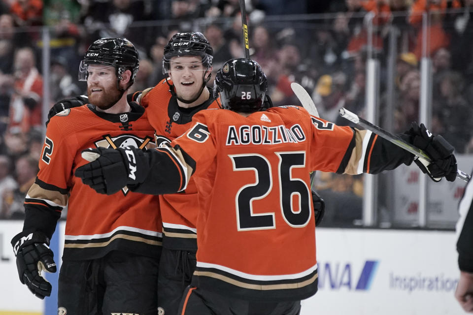 Anaheim Ducks defenseman Brendan Guhle, middle, celebrates after scoring with Matt Irwin, left, and Andrew Agozzino during the second period of an NHL hockey game against the Pittsburgh Penguins in Anaheim, Calif., Friday, Feb. 28, 2020. (AP Photo/Chris Carlson)