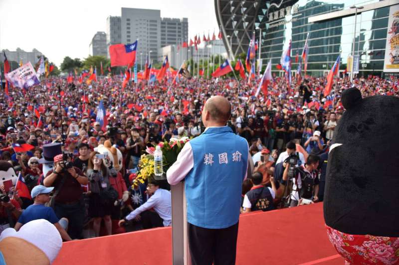 210191010-高雄市政府10日舉行國慶升旗典禮，高雄市長韓國瑜上台致詞，台下群眾揮舞國旗。（高雄市政府提供）