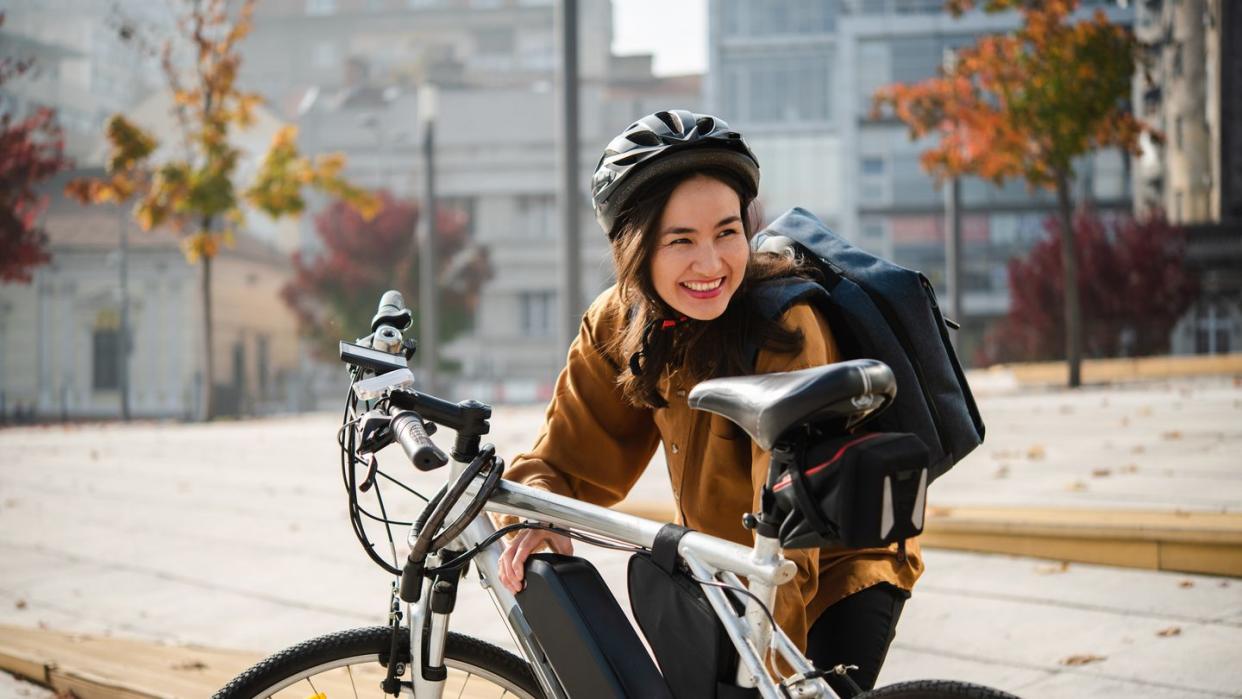 asian businesswoman preparing her e bike to go to work on it