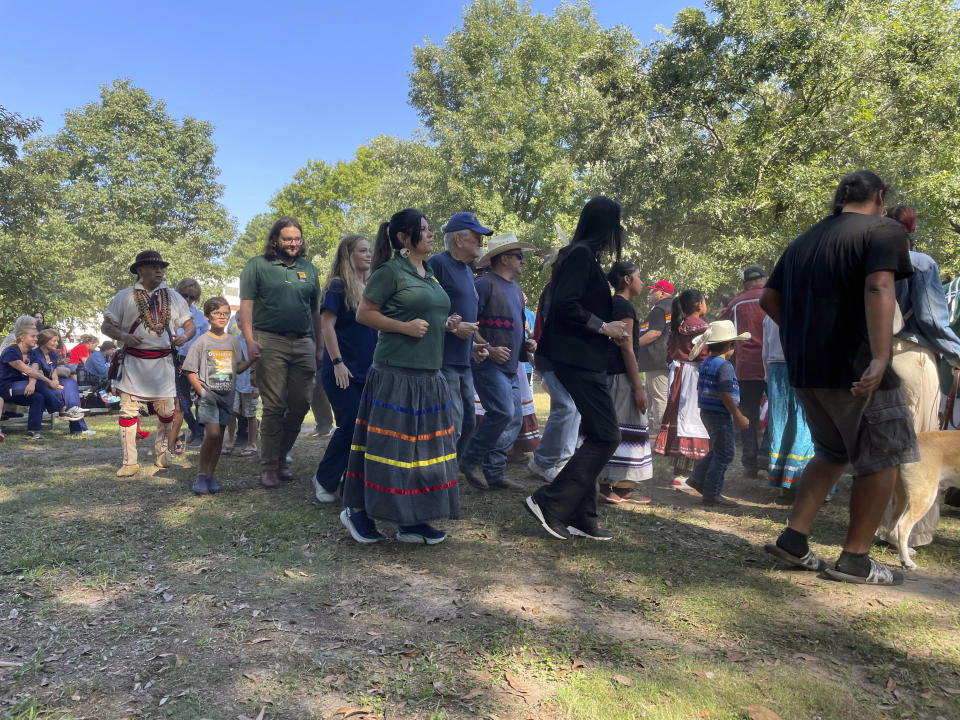 Tracie Revis, center, joins fellow citizens of the Muscogee (Creek) Nation and visitors to the mounds in an exhibition of a stomp dance at the 30th annual Ocmulgee Indigenous Celebration, on Sept. 17, 2022, in Macon, Ga. Revis is advocacy director for the Ocmulgee National Park and Preserve Initiative. (AP Photo/Michael Warren)