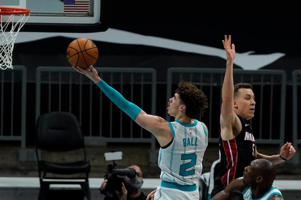 Charlotte Hornets guard LaMelo Ball drives to the basket past Miami Heat Sunday. On the play, Ball switched hands in midair for a left-handed layup.