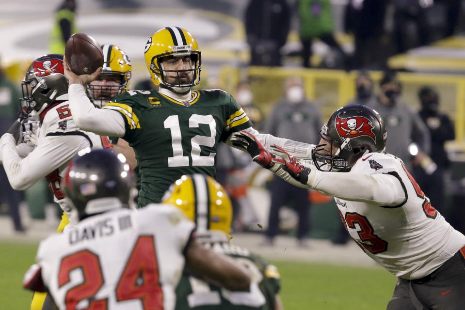 Green Bay Packers quarterback Aaron Rodgers (12) evades a tackle as he looks to pass against the Tampa Bay Buccaneers during the second half of the NFC championship NFL football game in Green Bay, Wis., Sunday, Jan. 24, 2021. (AP Photo/Mike Roemer)