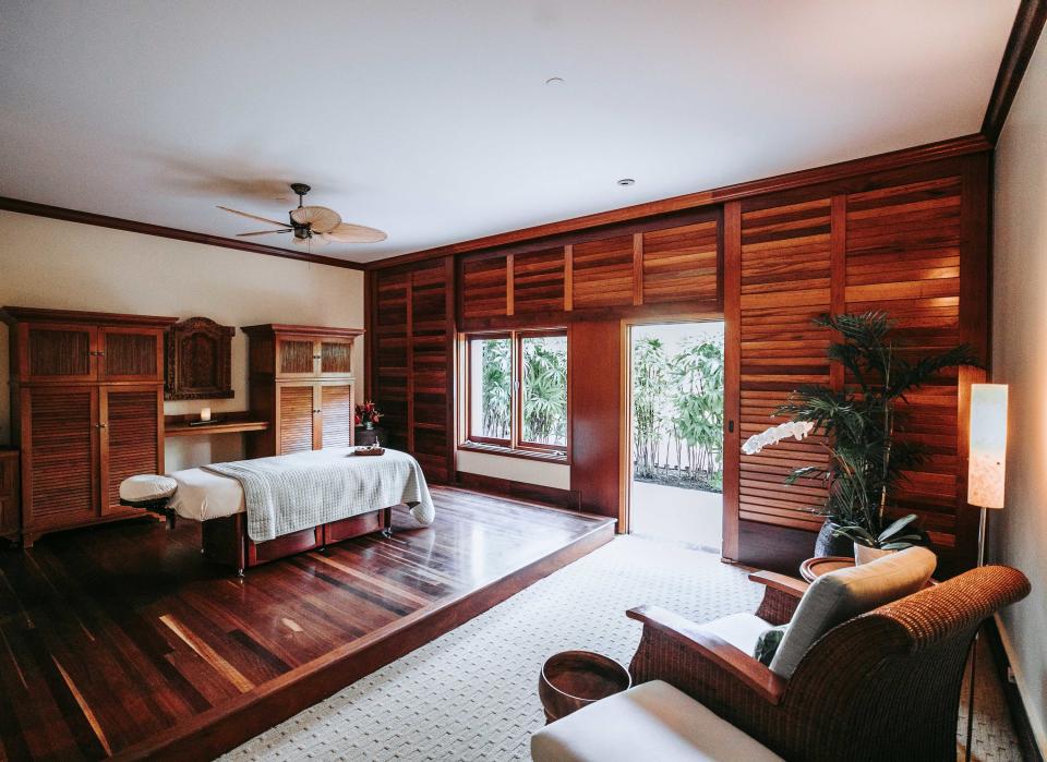 A room with dark wooden walls, a raised platform, and modern furniture