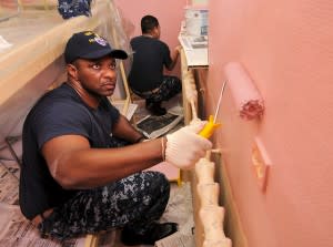 Soldiers painting a wall pink